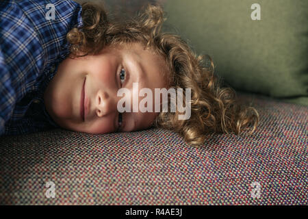 Kleiner Junge auf seinem Sofa im Wohnzimmer zu Hause liegen Stockfoto