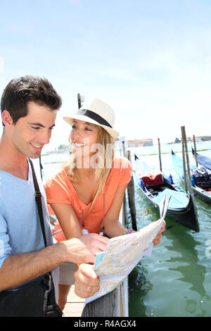 Touristen, die auf der Suche an der Karte vor der Insel San Giorgio Maggiore, Venedig Stockfoto