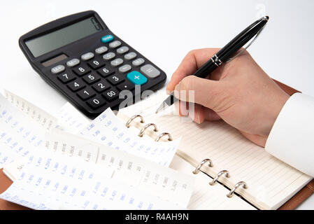 Hände der Unternehmer schriftlich eine Quittung auf einem Notebook, Cross-up Stockfoto
