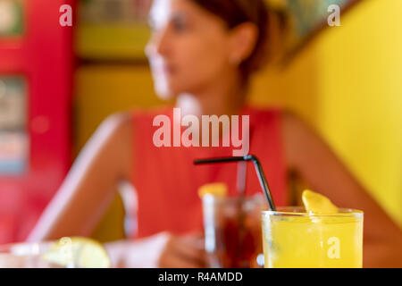Junge Frau trinkt Erfrischungen im Restaurant Stockfoto