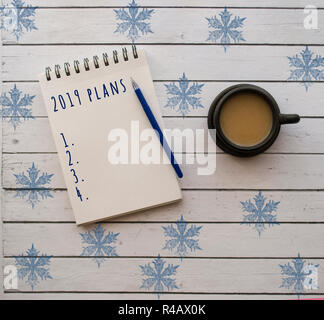 Ansicht von oben 2019 Ziele in einem Notizbuch aus Papier mit Tasse Kaffee auf weiße Holztisch Liste. Neues Jahr Auflösung Konzept. Stockfoto