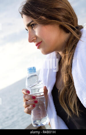 Frau trinkt Wasser nach sportlichen Aktivitäten Stockfoto