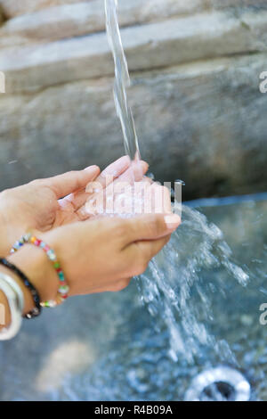 Woman's Hände mit Wasser spritzen. Stockfoto