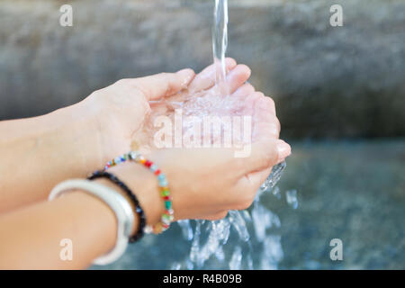 Woman's Hände mit Wasser spritzen. Stockfoto