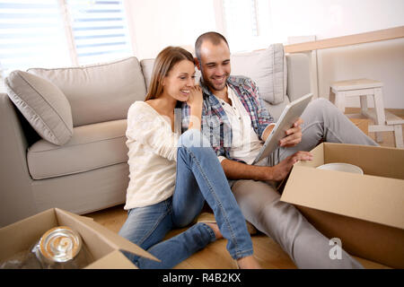 Junge Erwachsene mit Tablette wie bewegen Sie sich in die Stockfoto