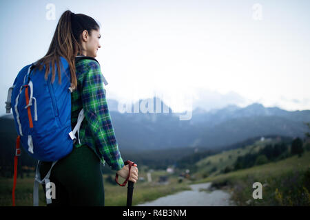 Junge Frau Wanderungen in den Bergen mit schöner Aussicht Stockfoto