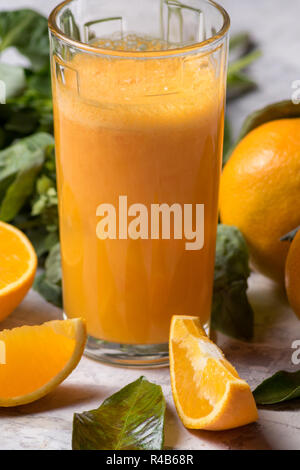 Orangensaft in ein Glas und reifen Mandarin oder Tangerine Obst mit grünen Blättern, weißen Hintergrund. Stockfoto