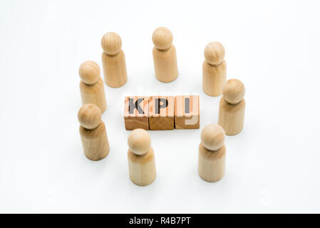 Holzfiguren als Business Team im Kreis um akronym KPI Key Performance Indicator, auf weißem Hintergrund, minimalistisches Konzept Stockfoto