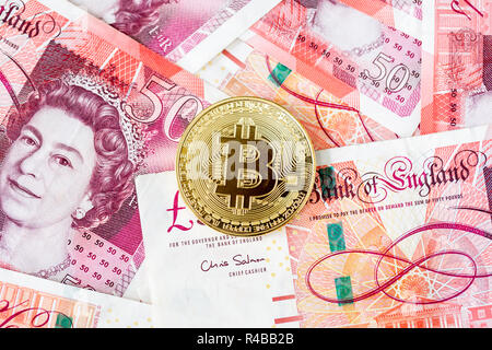 Bitcoin mit einem Stapel von 50 Pfund Sterling bank Notes Stockfoto