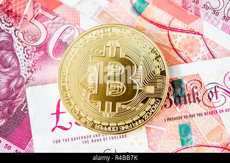 Bitcoin mit einem Stapel von 50 Pfund Sterling bank Notes Stockfoto