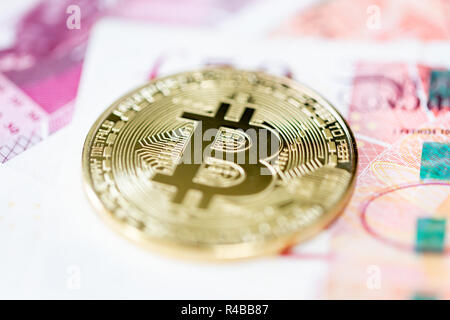 Bitcoin mit einem Stapel von 50 Pfund Sterling bank Notes Stockfoto