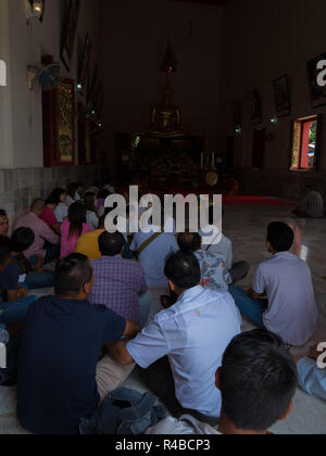 Der liegende Buddha Tempel in Hat Yai, Thailand. In einer Halle, die Menschen beten. Stockfoto