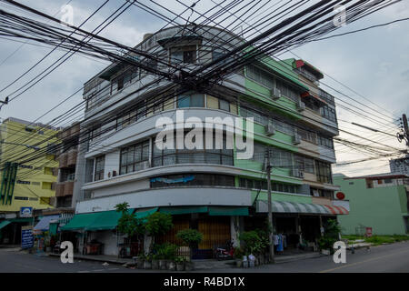 Stromleitungen dominieren die Skyline vor einem Gebäude im Art-Deco-Stil in Hat Yai, Thailand. Stockfoto