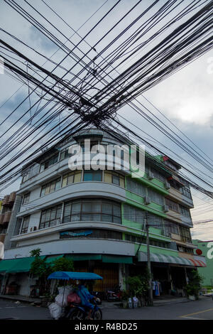 Stromleitungen dominieren die Skyline vor einem Gebäude im Art-Deco-Stil in Hat Yai, Thailand. Stockfoto
