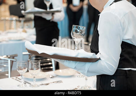 Kellnerin gekleidet in der Uniform, die eine Reihe von Weingläser Stockfoto