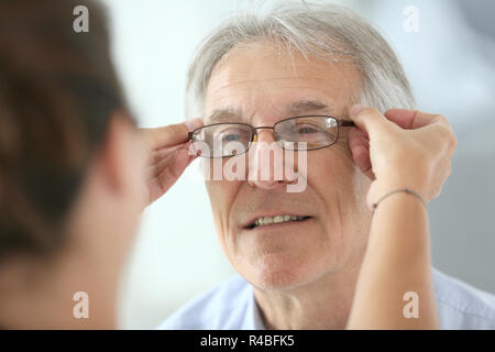 Älterer Mann, der versucht, neue Brillen Stockfoto