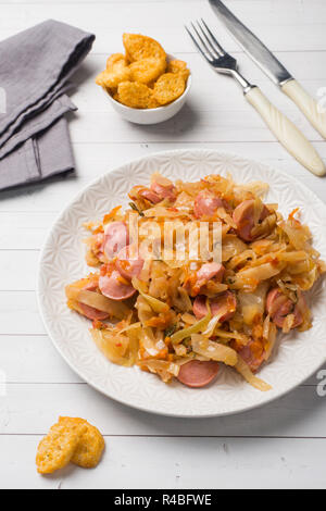 Gedünstetem Rosenkohl mit Würstchen auf einem Teller auf den Tisch. Selektiver Fokus Stockfoto