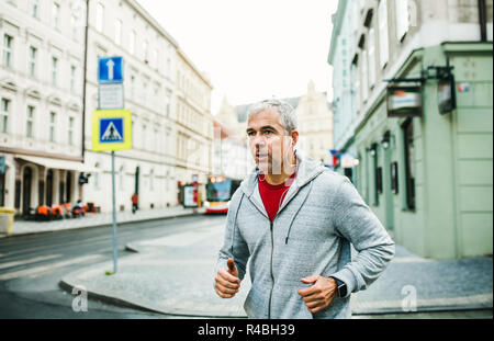 Reife männliche Läufer laufen draußen auf der Straße in Prag City. Stockfoto