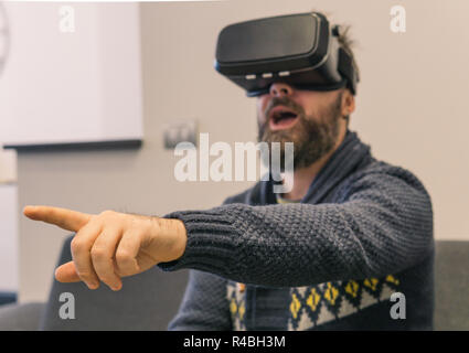 Porträt der jungen bärtigen Mann mit Virtual Reality im futuristischen Design Brille. Ausdruck der Verwunderung im Gesicht Stockfoto