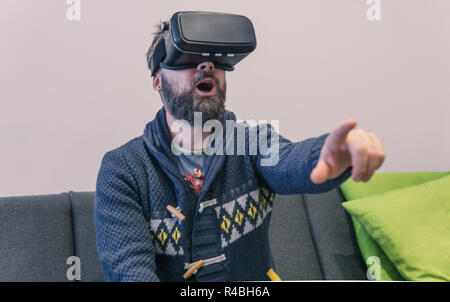 Porträt der jungen bärtigen Mann mit Virtual Reality im futuristischen Design Brille. Ausdruck der Verwunderung im Gesicht Stockfoto