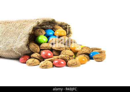 Bunte pepernoten behandelt in Jute Tasche auf weißem Hintergrund für die jährliche Sinterklaas holiday Event in den Niederlanden am 5. Dezember Stockfoto