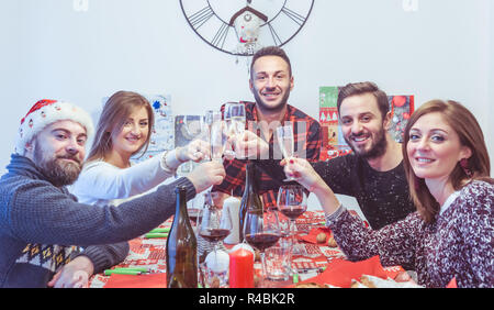 Gerne Freunde feiern Weihnachten und Neujahr am Tisch essen und trinken Stockfoto