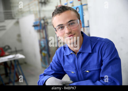 Portrait von lächelnden jungen Lehrling im Sanitär bereich Stockfoto