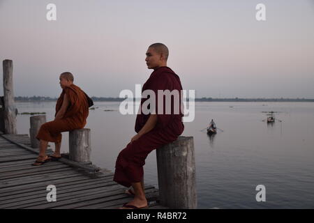 Buddhistische Mönche auf U-Bein bridge bei Sonnenuntergang in Amarapura, Myanmar Stockfoto