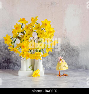 - Nahaufnahme, Still-life Bild der schöne Frühling Blumen des Narziss' Tete-a-Tete' ein Zwerg Narzisse. Schnittblumen in weißem Porzellan Vasen Stockfoto