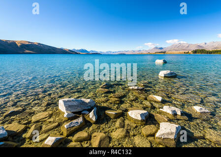 Kristallklare frische Gletscher Wasser an der pristine Lake Tekapo. Friedliche und ruhige Berglandschaft, Mackenzie Basin, Canterbury, Neuseeland. Stockfoto