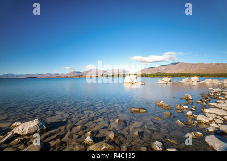 Kristallklare frische Gletscher Wasser an der pristine Lake Tekapo. Friedliche und ruhige Berglandschaft, Mackenzie Basin, Canterbury, Neuseeland. Stockfoto