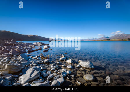 Kristallklare frische Gletscher Wasser an der pristine Lake Tekapo. Friedliche und ruhige Berglandschaft, Mackenzie Basin, Canterbury, Neuseeland. Stockfoto