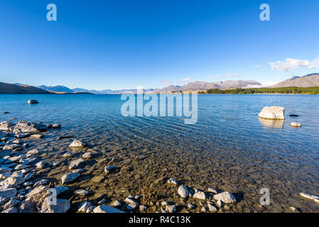 Kristallklare frische Gletscher Wasser an der pristine Lake Tekapo. Friedliche und ruhige Berglandschaft, Mackenzie Basin, Canterbury, Neuseeland. Stockfoto