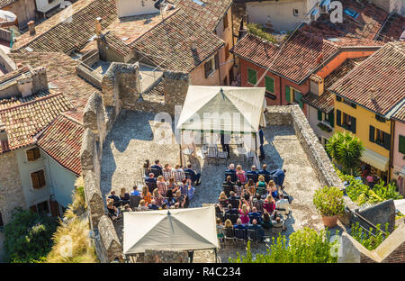 Ein paar die Hochzeit im Freien in der Scaliger Burg der mittelalterlichen Stadt Malcesine am Gardasee feiert, Norditalien. Ansicht von oben Stockfoto