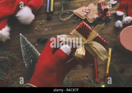 Hand mit Weihnachtsgeschenk verpackt in einer Box für fröhliche Feiertage Stockfoto