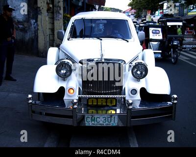 ANTIPOLO CITY, Philippinen - 24. NOVEMBER 2018: Eine weiße Leichenwagen oder Beerdigung Auto auf einem Bürgersteig geparkt. Stockfoto