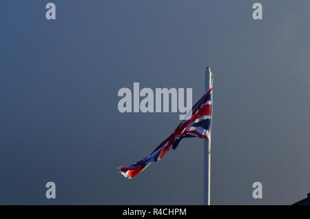 Union Jack in den Wind zu einem grauen Hintergrund Stockfoto