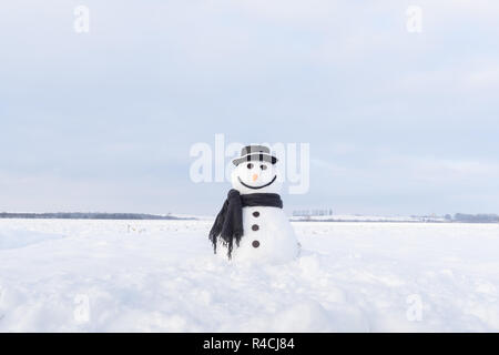 Lustige Schneemann in stylischen Hut und schwarzen scalf auf schneebedeckten Feld Stockfoto