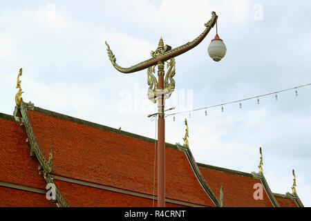 Thai Vintage Racing Boot geformten Street Lamp gegen den Tempel Ziegeldach und bewölkter Himmel, historischer Ort in der Provinz Nan, Thailand Stockfoto