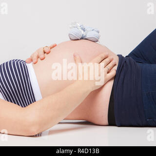 Schwangere Frau hielt ihre Hände auf schönen Bauch Stockfoto