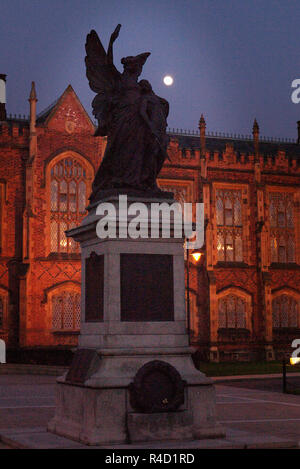 Der Mond über dem War Memorial und die vordere Fassade des Lanyon Gebäude, Queen's University, Belfast, Nordirland in der Nacht. Stockfoto