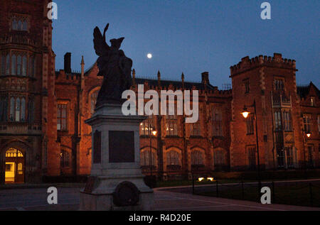 Der Mond über dem War Memorial und die vordere Fassade des Lanyon Gebäude, Queen's University, Belfast, Nordirland in der Nacht. Stockfoto