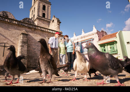 Großeltern und Enkel füttern Tauben auf Ferien in Kuba Stockfoto