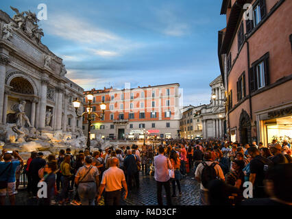 Touristen Masse der Piazza rund um den Trevi-brunnen als die Sonne untergeht und die Lichter angehen in Rom, Italien Stockfoto