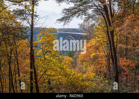 Die großen stählernen Bogen New River Gorge Bridge in West Virginia ist von bunten Herbstlaub gerahmt als vom Zentrum der Canyon Rim Besucher angezeigt. Stockfoto