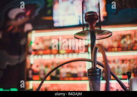 Shisha auf einem dunklen Hintergrund einer verschwommenen Bar mit Bokeh. Kopieren. Stockfoto