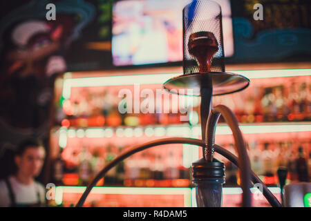 Shisha auf einem dunklen Hintergrund einer verschwommenen Bar mit Bokeh. Kopieren. Stockfoto