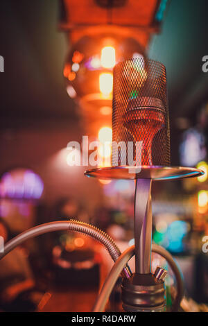 Shisha auf einem dunklen Hintergrund einer verschwommenen Bar mit Bokeh. Kopieren. Stockfoto