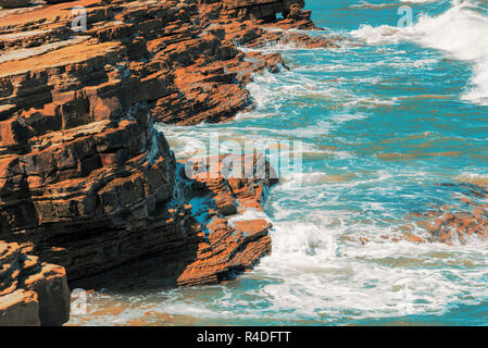Blue Ocean Wellen gegen die Felsen und Ufer. Stockfoto