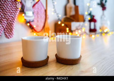 Weiße Tassen auf den Ständer. gemütliche Weihnachten Dekor Girlande bokeh. Küche neues Jahr 2019. Stockfoto